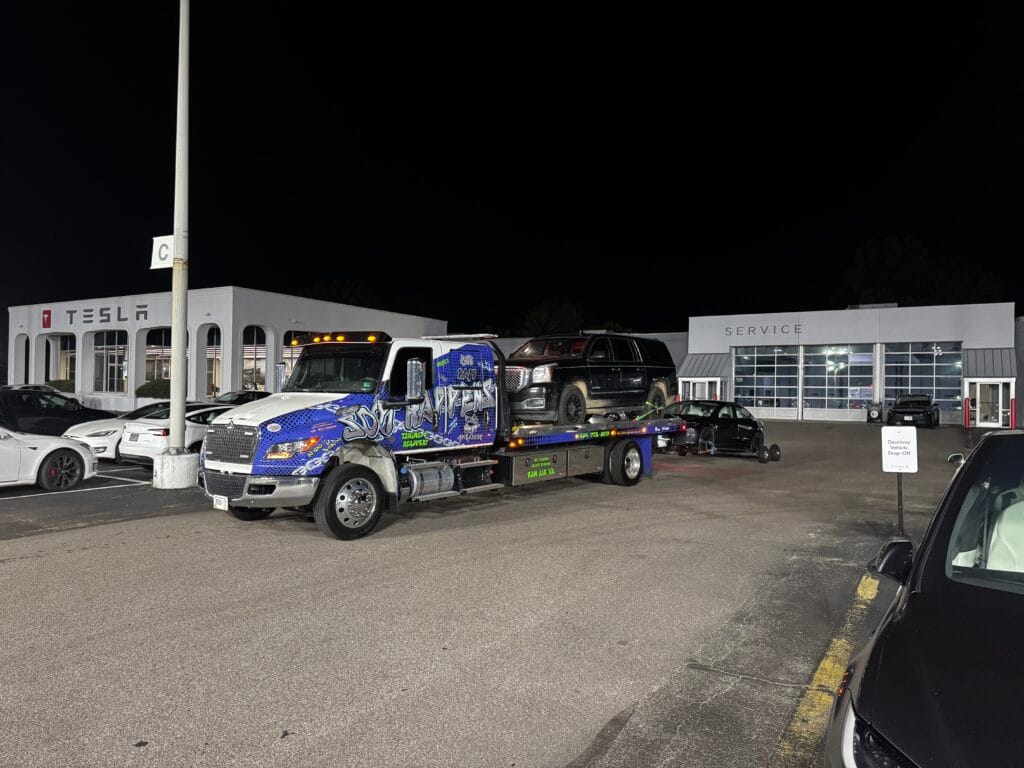 Soot Happens rollback at a Tesla service center at night